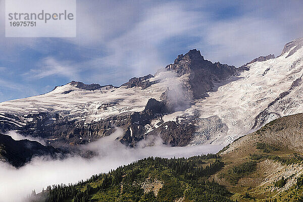 Schnee und Wolken akzentuieren die Gebirgsstrukturen von Felsspalten und Gipfeln