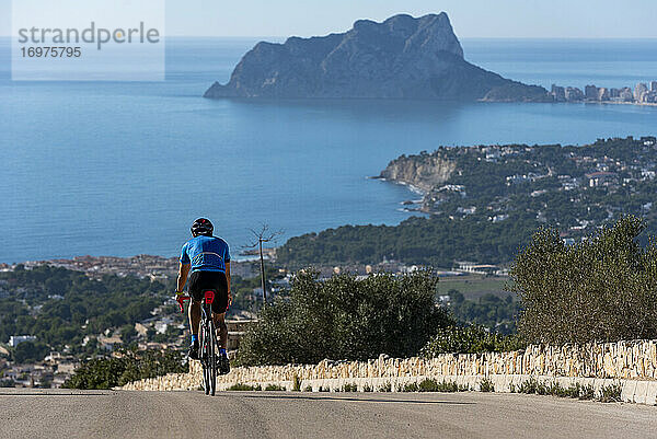 Radfahrer  der den Hügel Cumbre del Sol mit Blick auf das Mittelmeer hinunterfährt.