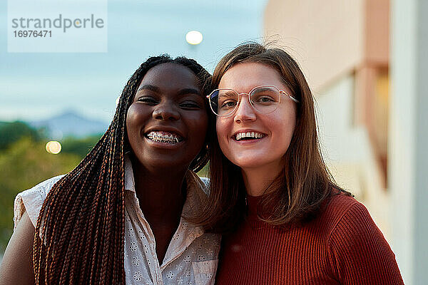 Zwei Studenten lächeln und schauen in die Kamera. Multiethnisches Konzept