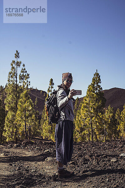 Starke Wanderin macht Selfie mit Smartphone im Bergwald