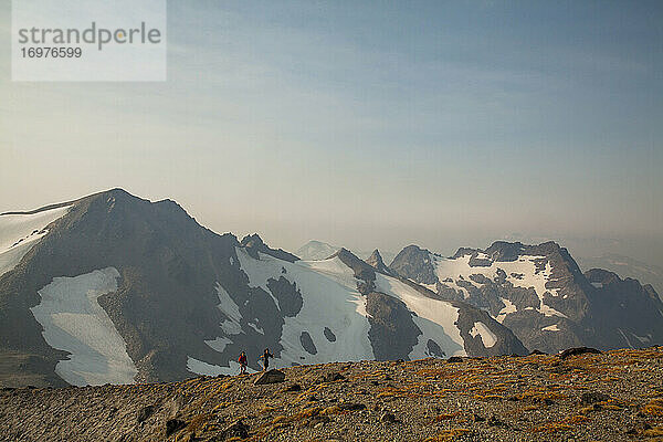 Zwei Wanderer besteigen den Gipfel des Glacier Peak in Washington.