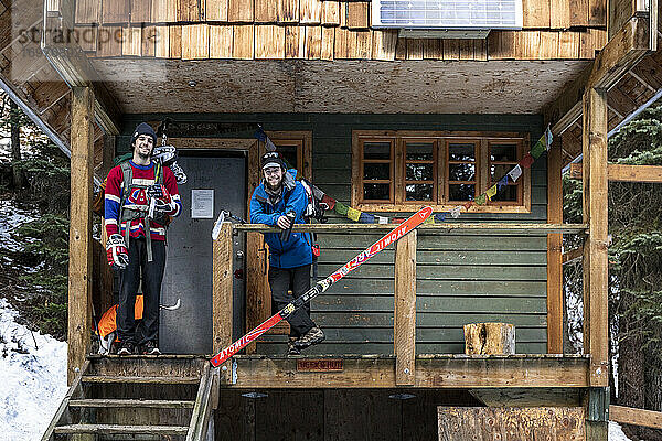 Männliche Eishockeyspieler stehen auf der Veranda einer Hütte