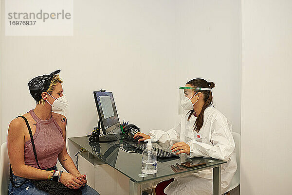 Eine Ärztin kümmert sich um ihre Patienten in der Klinik. Sie haben die Maske auf.