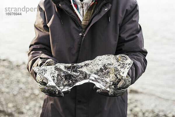 Halten eines kleinen Eisbergs in Jokulsarlon