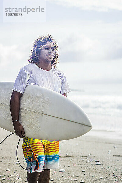 Surfer in Costa Rica am Strand stehend