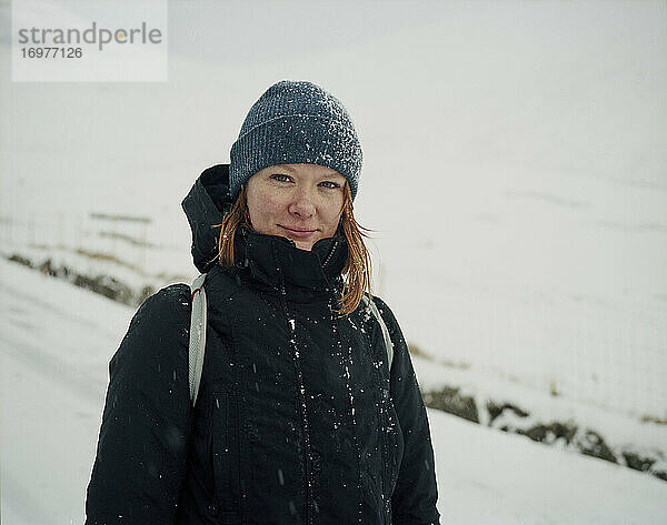 Porträt einer lächelnden Frau im Schnee  die in die Kamera schaut  auf den Färöer Inseln