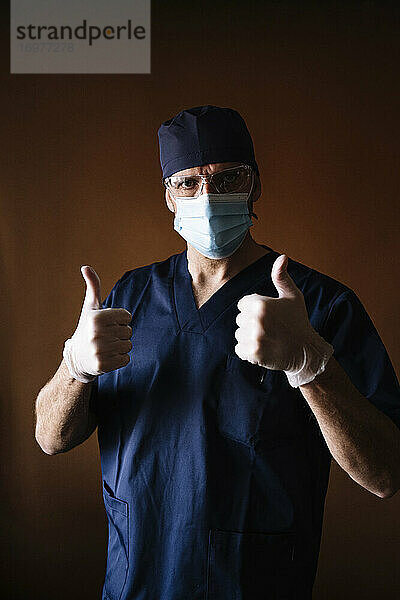 Oberarzt  medizinischer Fachmann  der breit lächelt und eine Geste in Richtung Kamera zeigt  Ausdruck von Sympathie und Zustimmung isoliert