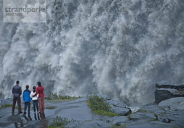Familie am Rande des mächtigen Wasserfalls Dettifoss