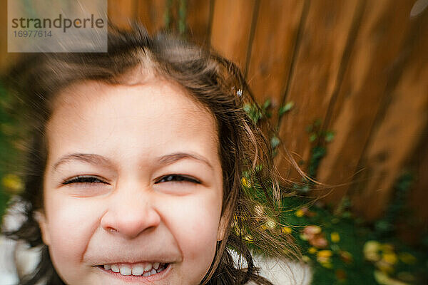 Nahaufnahme eines kleinen Mädchens  das draußen lächelt  mit Linsenunschärfe-Effekt