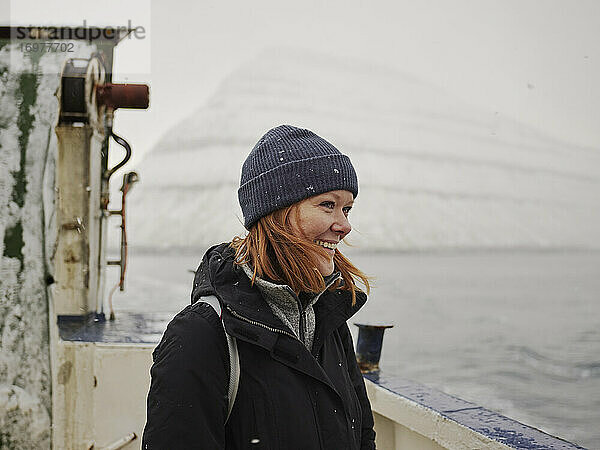 Frau auf Fähre mit Blick auf die Berge der Färöer Inseln