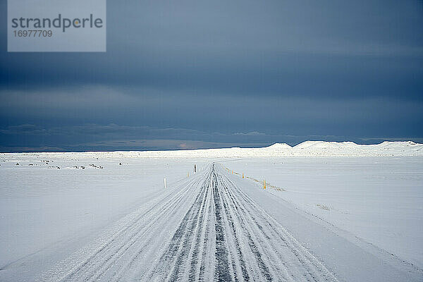 Verschneite Straße in winterlicher Landschaft