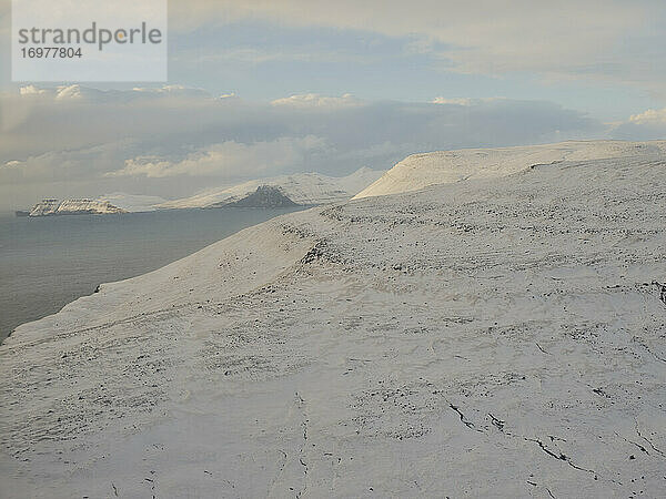 Luftaufnahme von verschneiten Bergen auf den Färöer Inseln