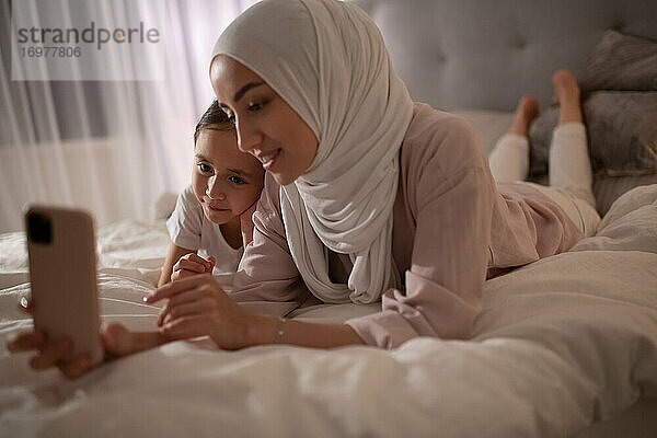 Muslimische Frau und Mädchen sprechen online mit ihrem Vater