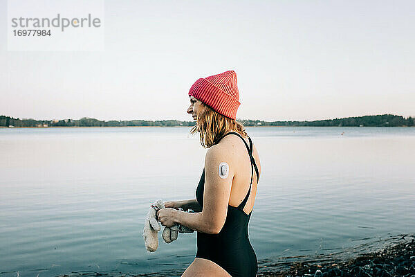 Frau im ruhigen Wasser  bereit zum Kaltwasserschwimmen in Schweden
