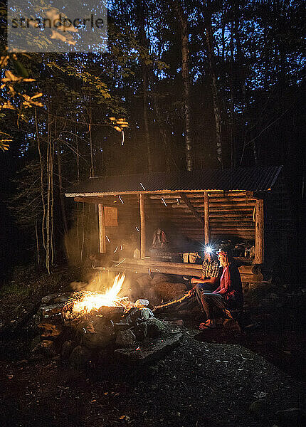 Ein Paar sitzt an einem Lagerfeuer vor einer Schutzhütte auf dem Appalachian Trail