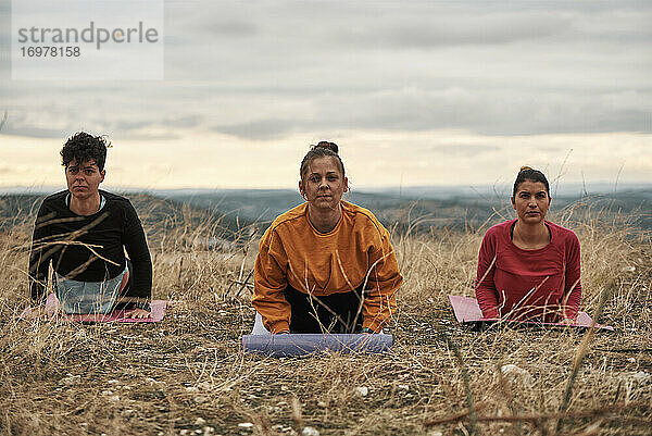 3 junge Frauen üben Pilates im Freien