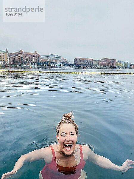 Lächelnde Frau voller Freude Kaltwasserschwimmen in Dänemark