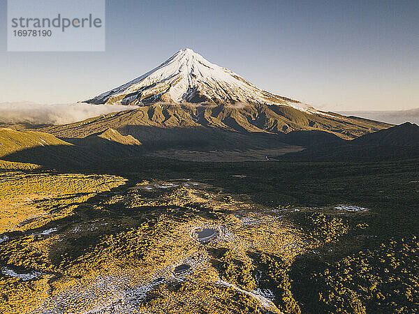 Der Vulkan Mount Taranaki nach dem ersten Schneefall der Saison bei Sonnenuntergang  Neuseeland.