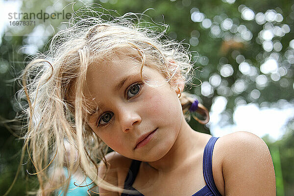 Porträt eines Mädchens  das mit ernstem Gesichtsausdruck in die Kamera schaut  Nahaufnahme