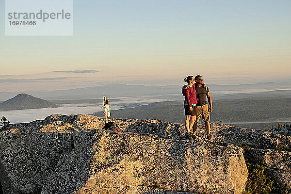 Ehepaar umarmt sich nach Erreichen des Gipfels in Maine