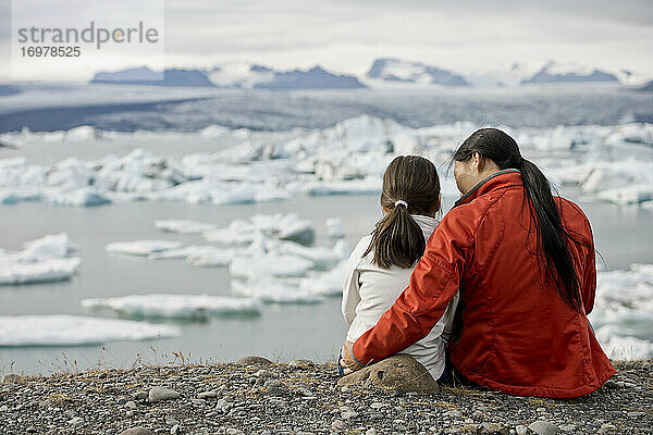 Mutter und Tochter betrachten eine Gletscherlagune in Island