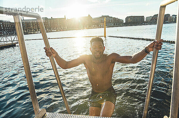 Multirassischer Millennial klettert nach kaltem Schwimmen in Süddänemark heraus