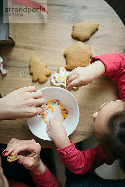 Mutter und Tochter haben Spaß mit Keksen in der Küche.