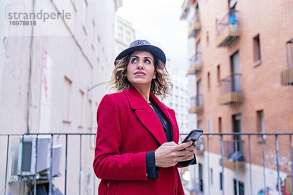 Frau in roter Jacke benutzt ihr Smartphone