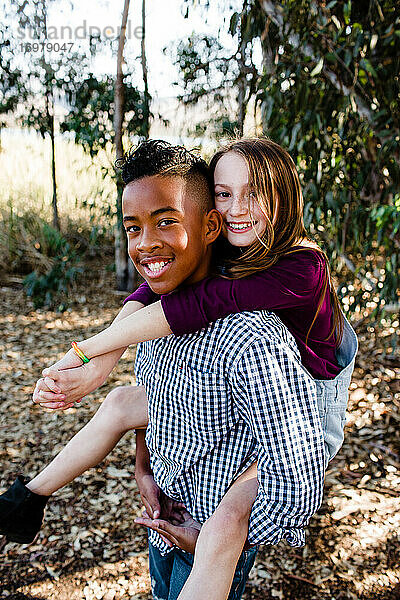 Bruder und Schwester Huckepack im Park in Chula Vista