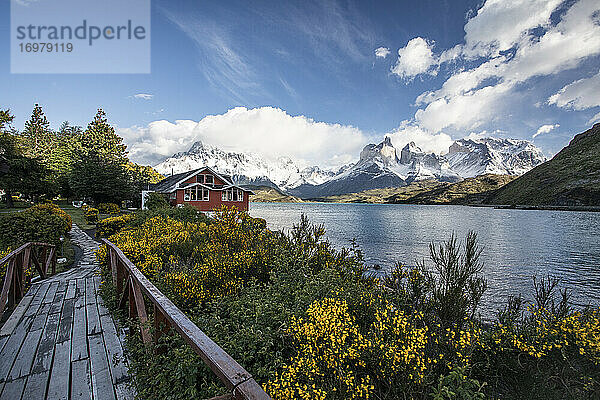 Ein kleines rotes Gebäude vor den Gipfeln des Torres Del Paine