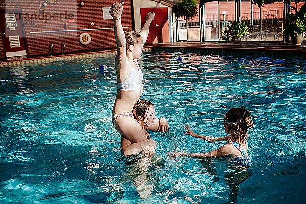 Drei Mädchen spielen in einem Hallenschwimmbad