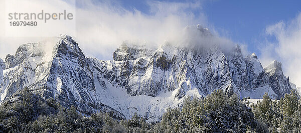 Wolken zwischen Bergen in einer verschneiten Panoramalandschaft im Winter