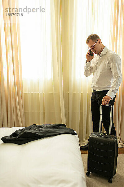 Erwachsener Geschäftsmann beim Telefonieren im Hotel