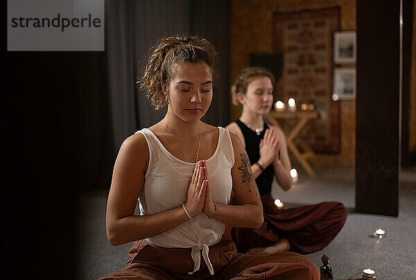 Friedliche Frau meditiert in der Nähe eines Freundes