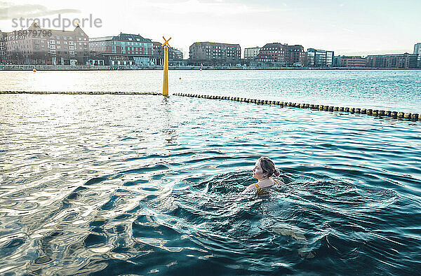 Millennial friedlich schwimmen in kaltem Wasser in Kopenhagen Dänemark