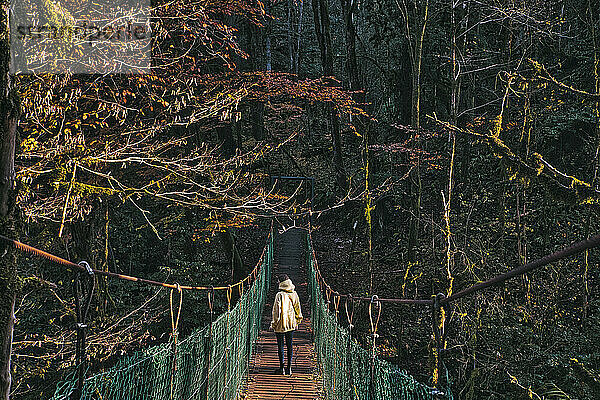 Junge Frau beim Überqueren einer Hängebrücke