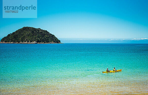 Zwei Personen beim Kajakfahren im blauen Wasser des Abel Tasman National Park