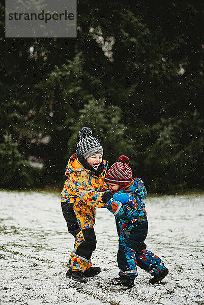 Kinder haben Spaß draußen im Park spielen im Schnee auf Wintertag Europa