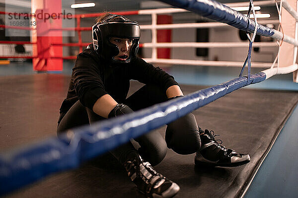 Müde Boxerin ruht sich nach dem Kampf im Fitnessstudio aus