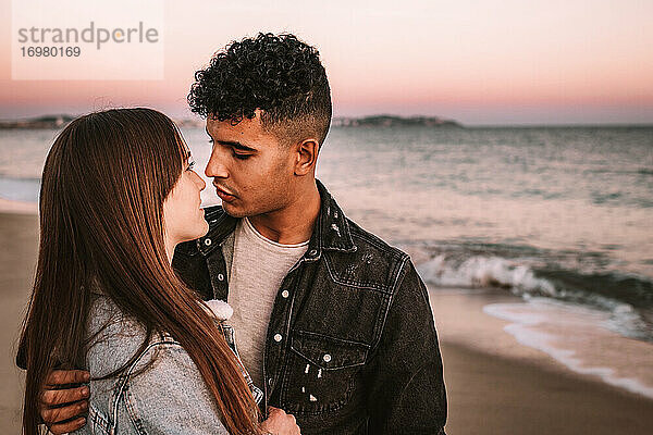 Nettes Bild eines jungen Paares am Strand  das sich gegenseitig anschaut