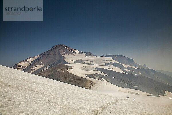 Zwei Wanderer klettern auf den Gipfel des Glaicer Peak in Washington.