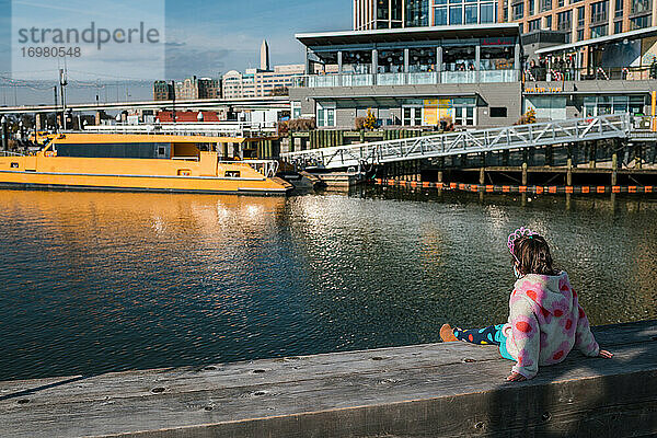 Junges Mädchen mit Diadem beobachtet Boote im Flusshafen