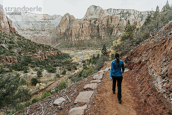 Wanderin wandert auf einem roten Feldweg im Zion National Park  Utah