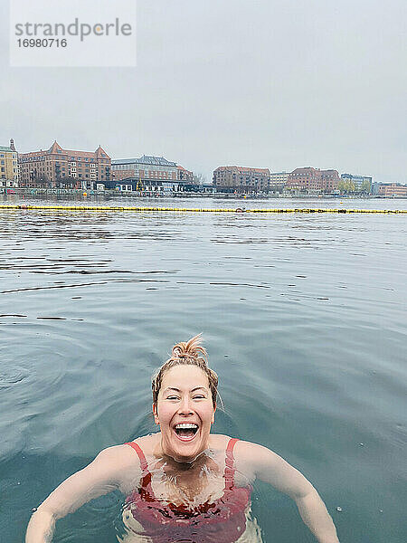Frau lachend und schwimmend in kaltem Wasser in Kopenhagen  Dänemark