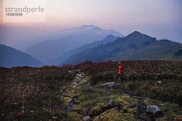 Ein Wanderer besteigt den Glacier Peak im frühen Morgenlicht in Washington.