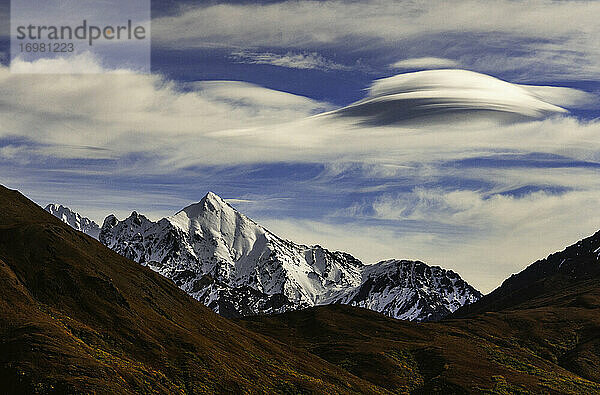 Linsenförmige Wolken bilden sich über zerklüfteten Bergen in einer Herbstlandschaft