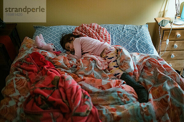 Junges Kind gemischter Rasse Mädchen schlafen im Bett mit rosa Bettdecke
