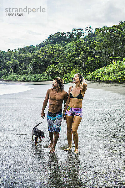 Multiethnisches Paar auf Costa Rica-Urlaub spaziert am Strand