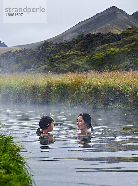 Mutter und Tochter nehmen ein Bad in einer geothermischen Quelle in Island