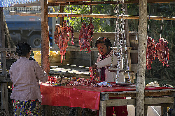 Mann verkauft Fleisch auf dem Straßenmarkt in einem Dorf am Inle-See  Nyaungs